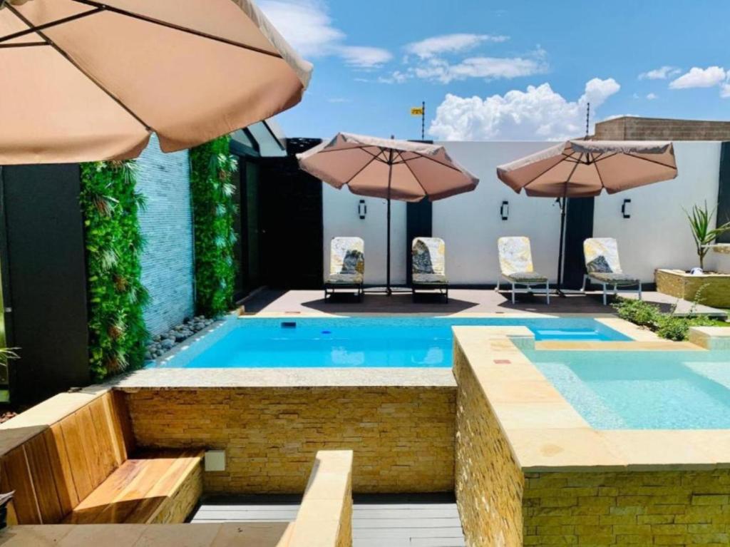 Essence Lifestyle Premium Windhoek: Pool mit Sonnenschirmen und Liegen