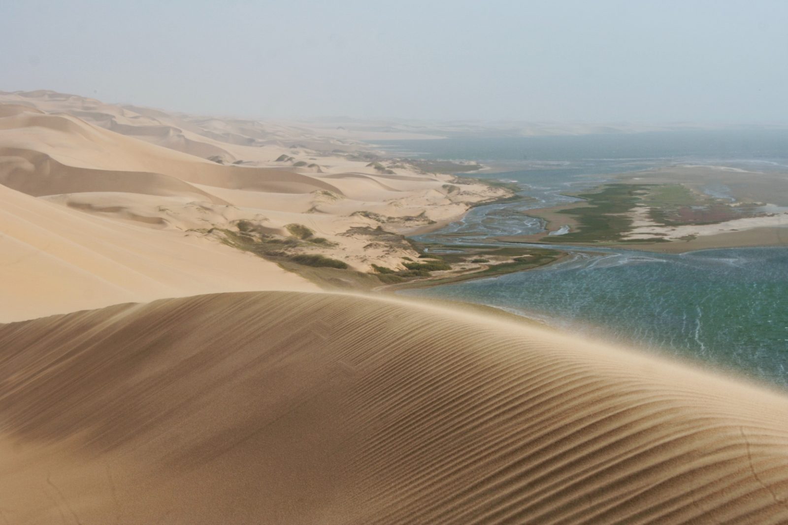 Dünen treffen auf die Lagune von Sandwich Harbour nahe Walvis Bay, Namibia